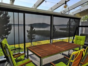 Musta, valoa suodattava tekninen rullaverho terasilla